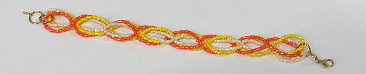 A beaded chain bracelet with alternating orange, yellow, and white beads, featuring gold-toned lobster clasp ends on a plain white background.