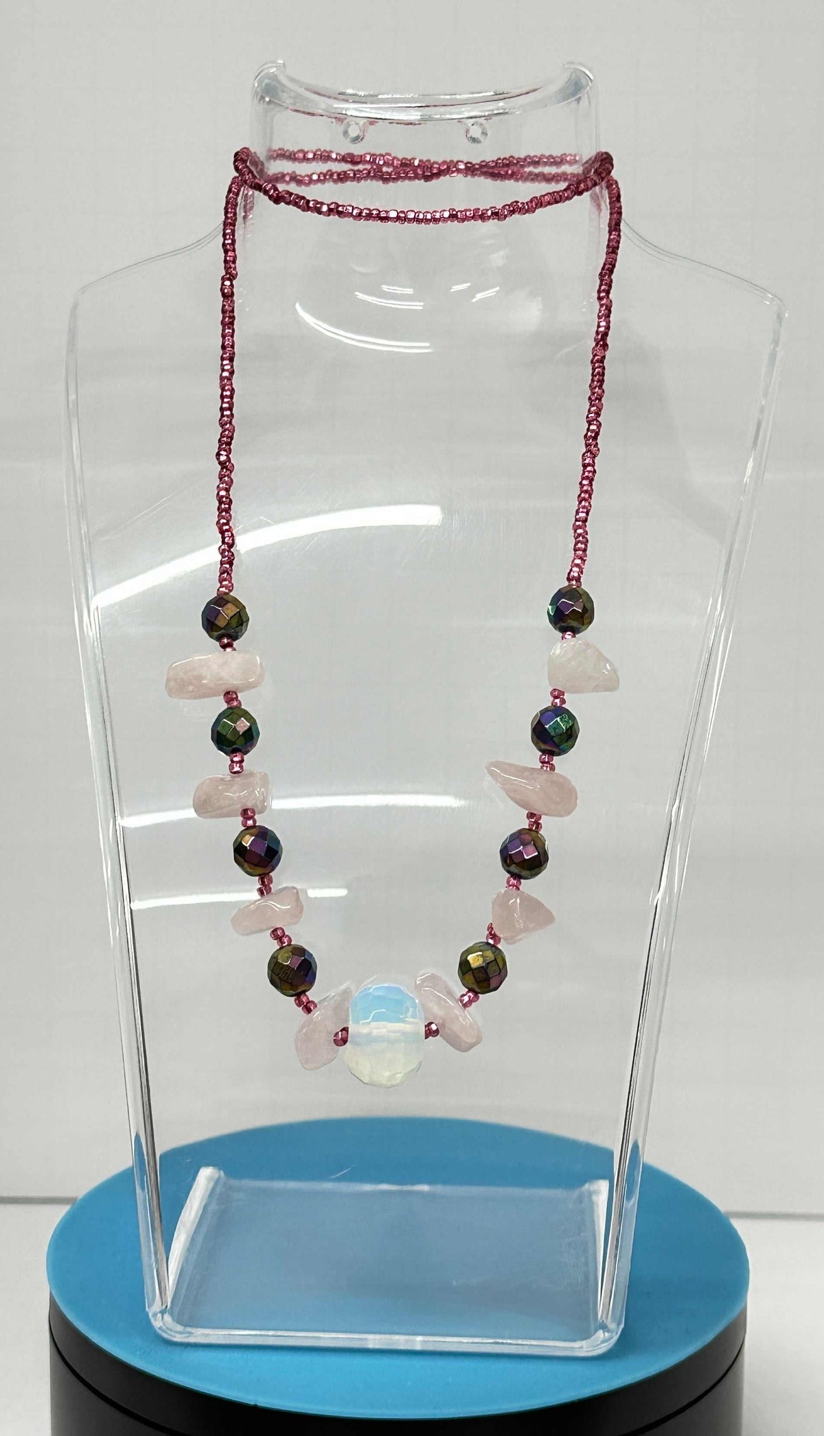 Necklaces Pullover NO Clasp with burgundy seed bead strands, iridescent beads, pale pink stones and a blue focal bead